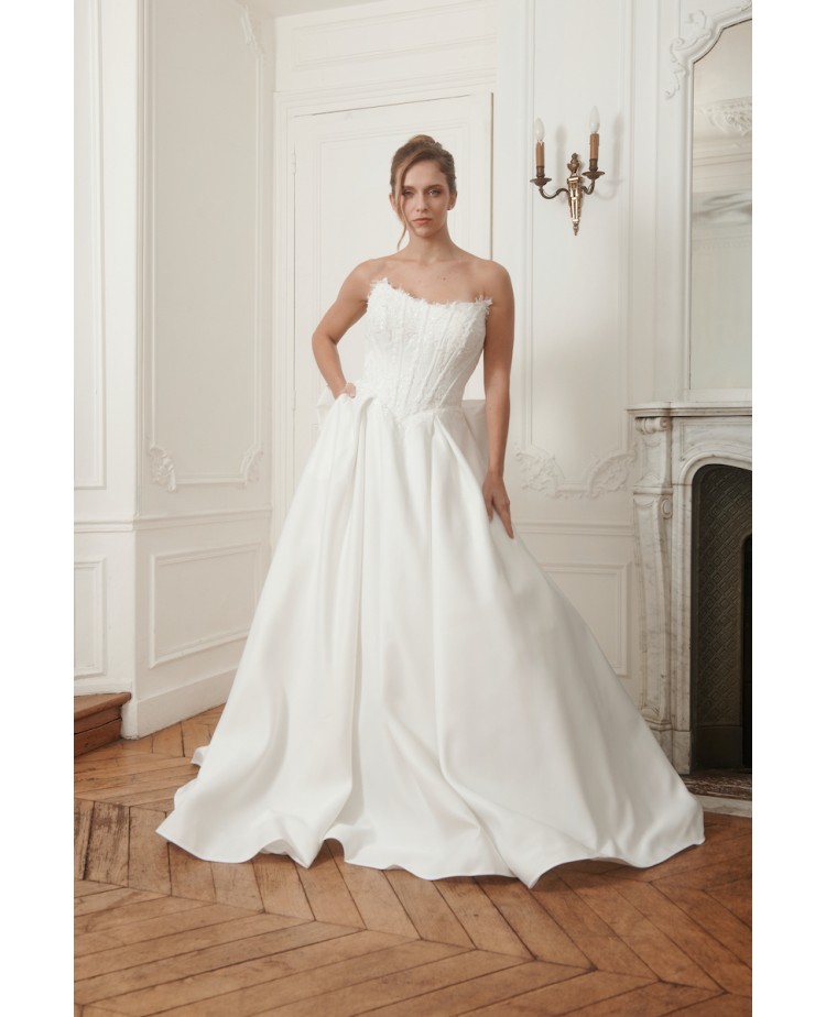 Robe de mariée bustier couture PRÉCIEUSE avec jupe volumineuse fluide et grand nœud dans le dos, disponible chez Promarried.